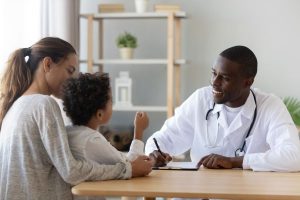 A mother and her child talking to a doctor.
