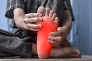 A man checking his foot for a tingling sensation.