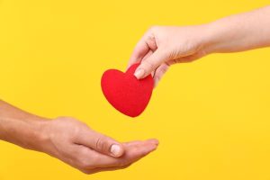 Blood donation, a woman giving a man a red heart