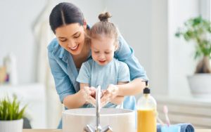 Spreading handwashing awareness by helping children wash their hands.
