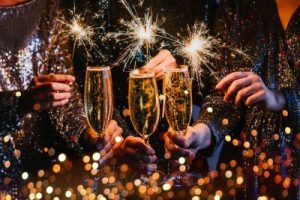 Friends celebrating Christmas or New Year's Eve party with Bengal lights and champagne.