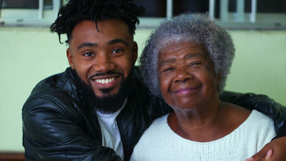 A young man affectionately embraces an older woman, both smiling at the camera. Learn how to prevent strokes at Rosen Medical Center.