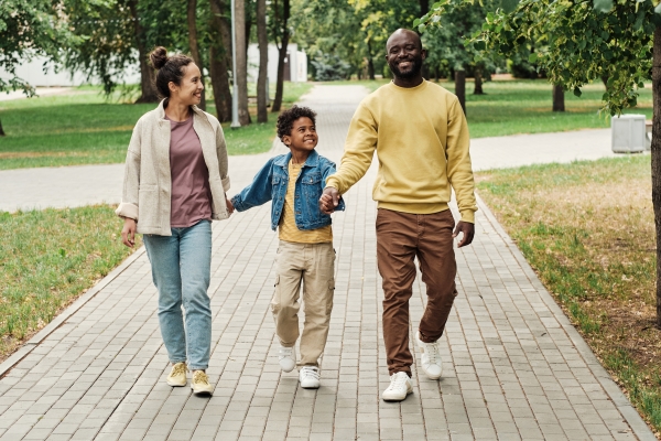 A mom, dad, and son go for a walk on an outdoor path.